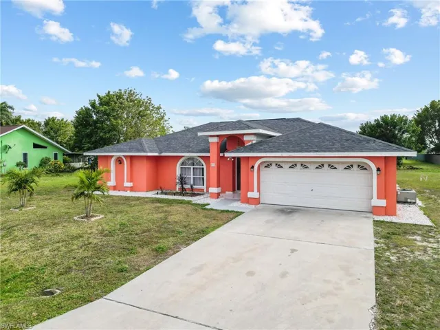 View of front of house with a garage and a front lawn