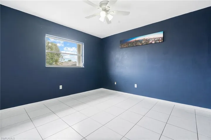 Tiled empty room featuring ceiling fan
