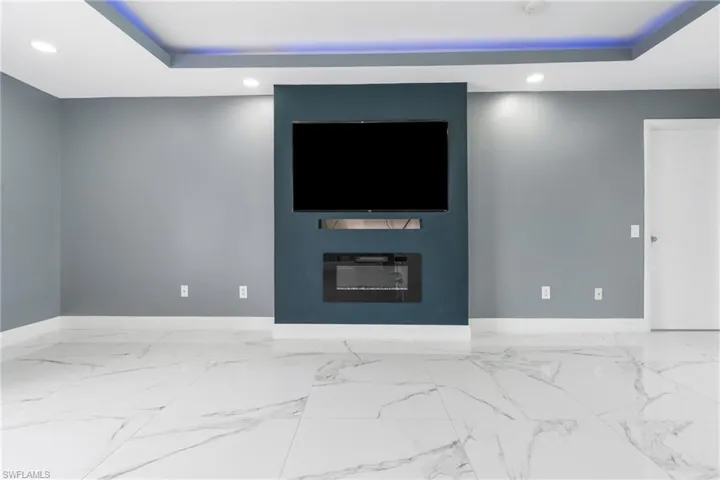 Unfurnished living room featuring a raised ceiling