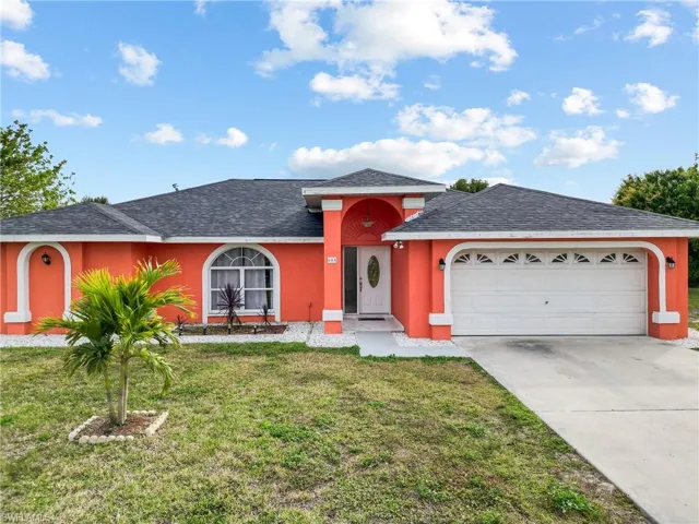 View of front facade with a garage and a front lawn