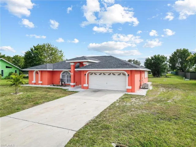 View of front of home with a garage and a front lawn