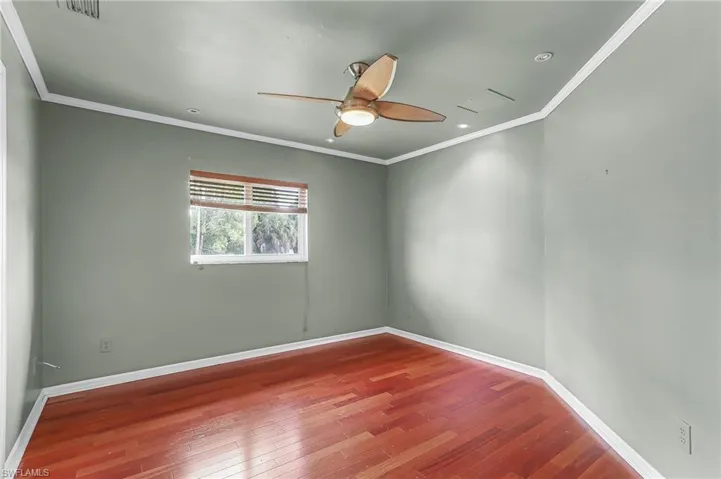 Unfurnished room featuring crown molding, hardwood / wood-style floors, and ceiling fan