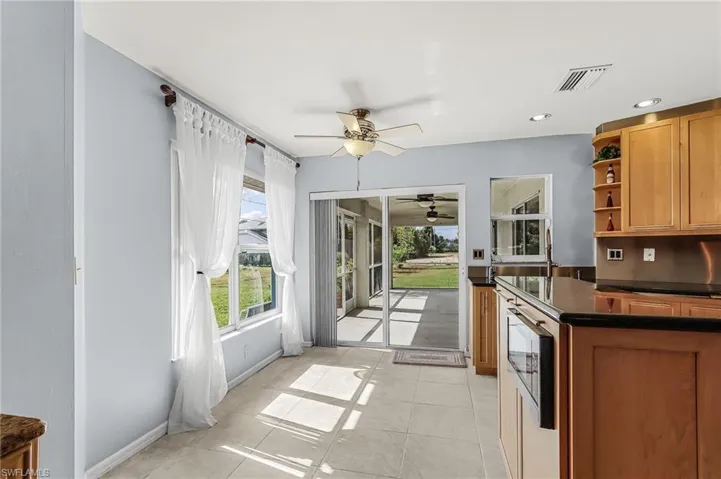 Kitchen with open shelves, a ceiling fan, recessed lighting, wood finish cabinets, and light tile patterned floors
