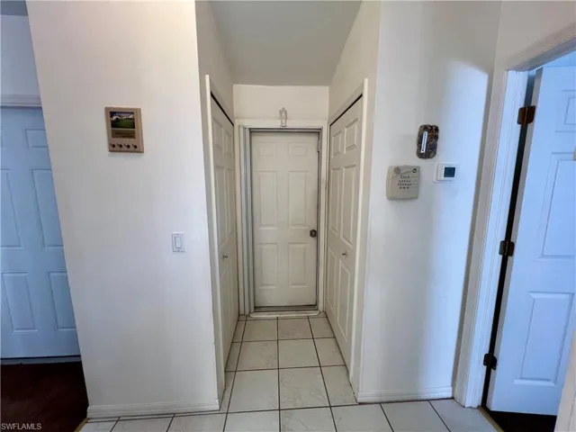 Hall with light tile patterned floors to pantry area
