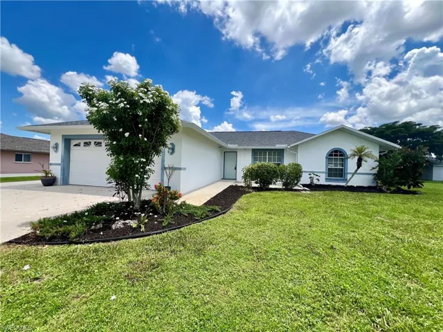 Single story home featuring a garage and a front yard