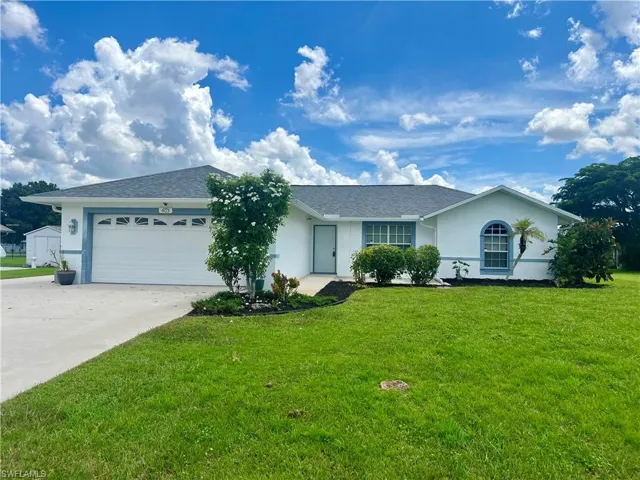 Single story home with a front yard and a garage