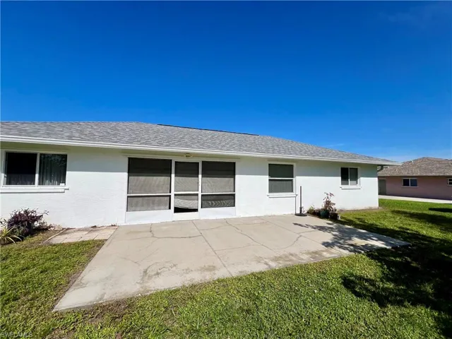 Back of property with a patio area and a lawn