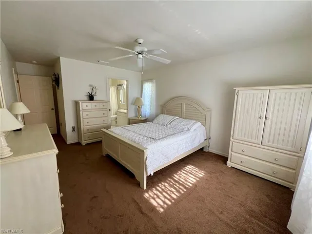 Bedroom with connected bathroom, ceiling fan, and carpet floors