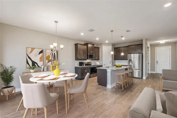Dining space with light wood-type flooring, an inviting chandelier, and sink