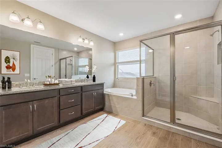 Bathroom with separate shower and tub, vanity, and hardwood / wood-style flooring