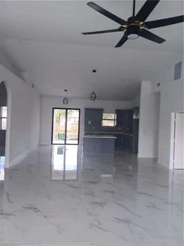 Empty room with ceiling fan and lofted ceiling