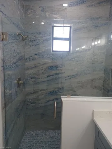 Bathroom with vanity and a shower with shower door