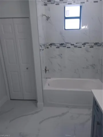 Bathroom with vanity and tiled shower / bath combo
