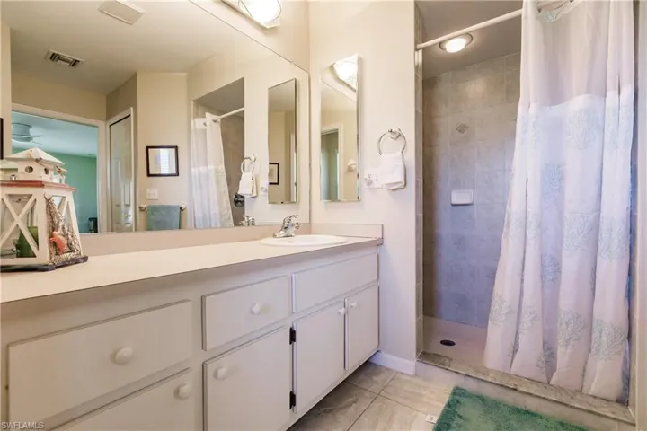 Bathroom with a shower with shower curtain and vanity