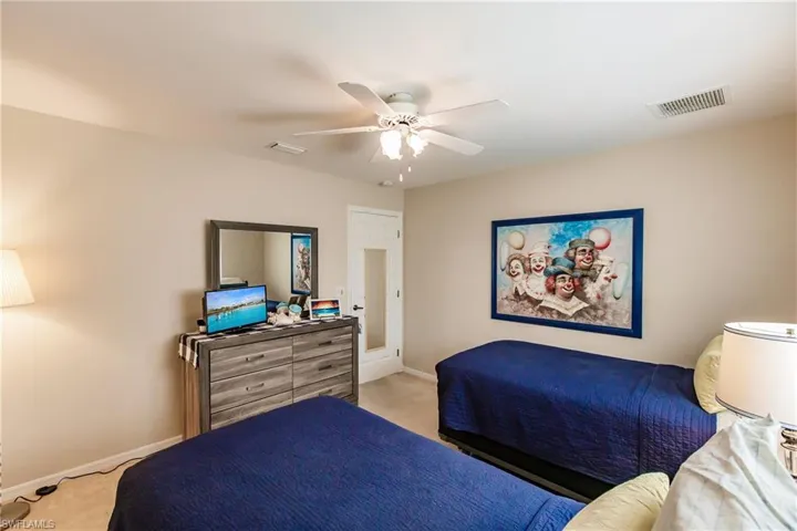 Bedroom with ceiling fan and light carpet