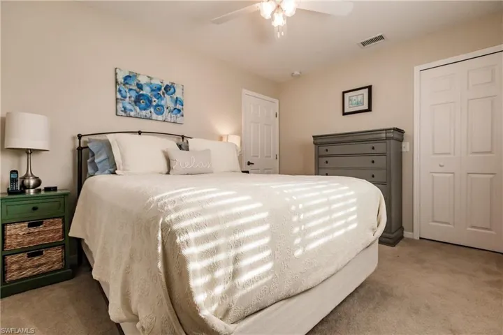 Carpeted bedroom featuring a closet and ceiling fan