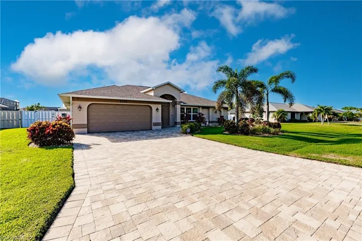 Ranch-style house with a garage and a front lawn
