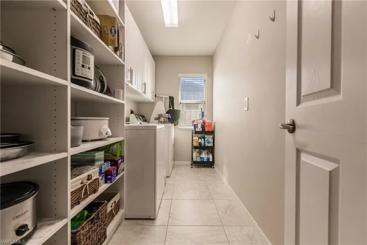 Washroom with washer and clothes dryer and cabinets