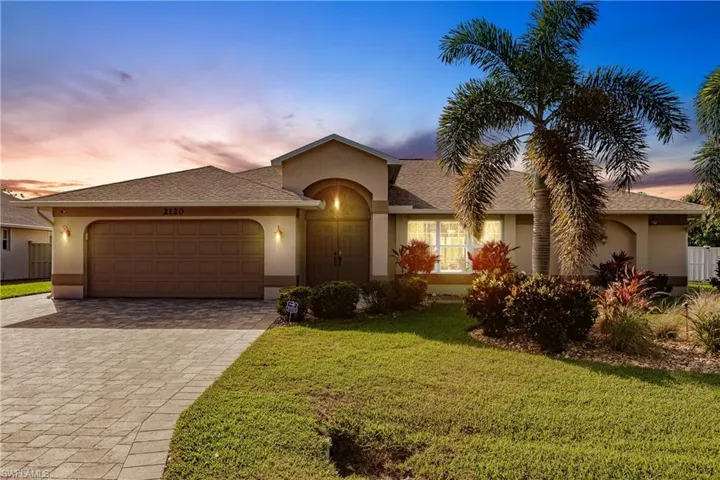 View of front of house with a lawn and a garage