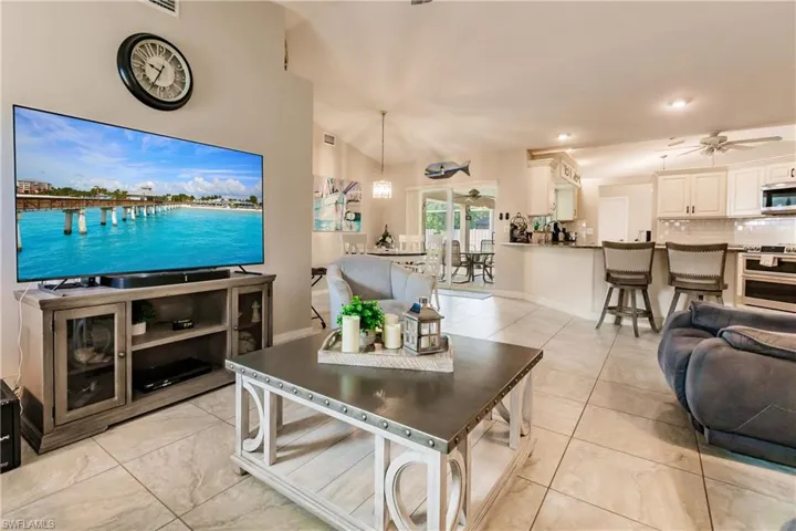 Living room featuring ceiling fan and lofted ceiling