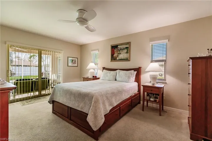 Carpeted bedroom with access to outside, multiple windows, and ceiling fan