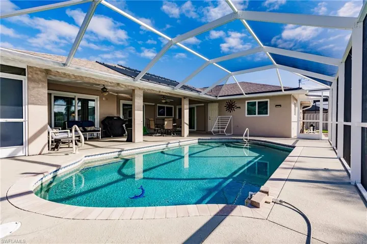 View of swimming pool with a patio, glass enclosure, and ceiling fan