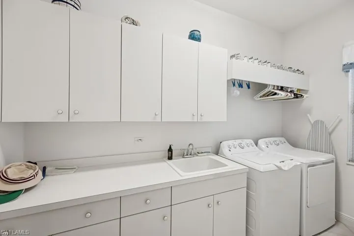 Washroom featuring cabinet space and washer and clothes dryer
