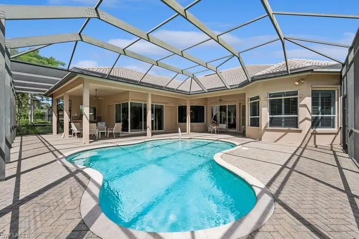 Swimming pool featuring ceiling fan, a patio, outdoor dining area, and a lanai