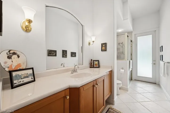 Full bath featuring vanity, tile patterned flooring, and a shower stall