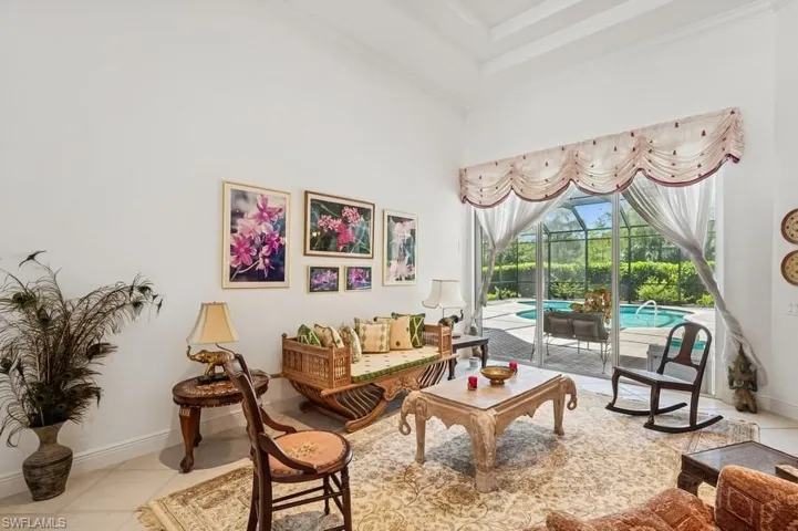 Living area featuring ornamental molding, a towering ceiling, and tile patterned flooring