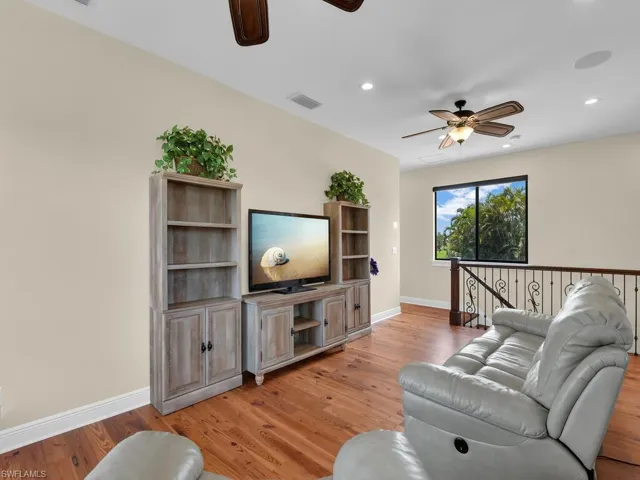Living area with a ceiling fan, light wood finished floors, baseboards, and recessed lighting