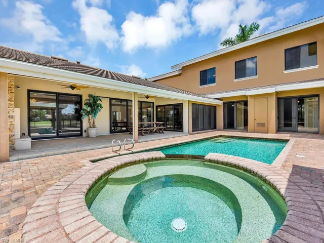 View of swimming pool with a ceiling fan, a pool with connected hot tub, and a patio area