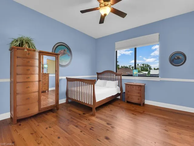 Bedroom with wood finished floors, baseboards, and a ceiling fan