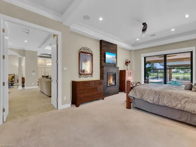 Bedroom with access to outside, crown molding, a fireplace, light colored carpet, and recessed lighting