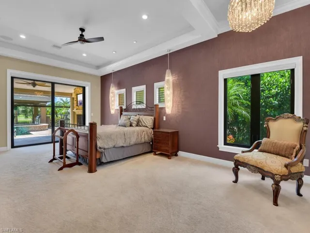 Bedroom with access to outside, light carpet, ornamental molding, baseboards, and a chandelier