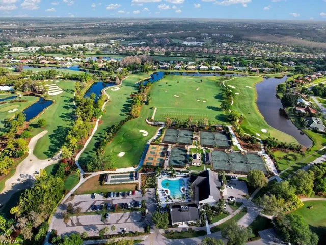 View of property location featuring a nearby body of water, a golf club, and nearby suburban area