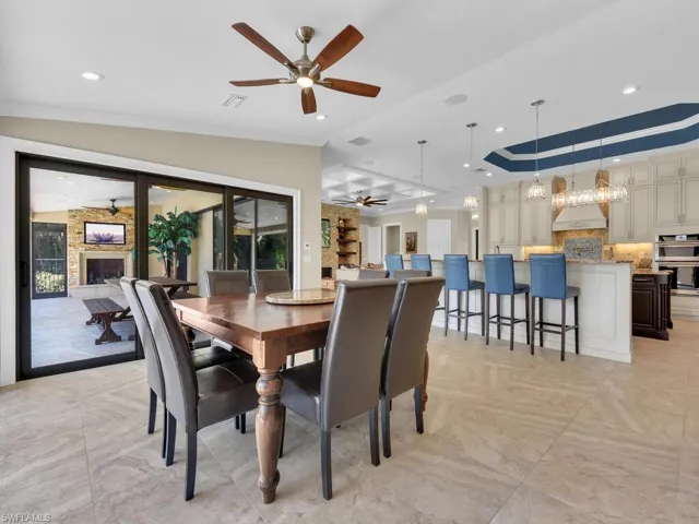 Dining room with ceiling fan, crown molding, a fireplace, and recessed lighting