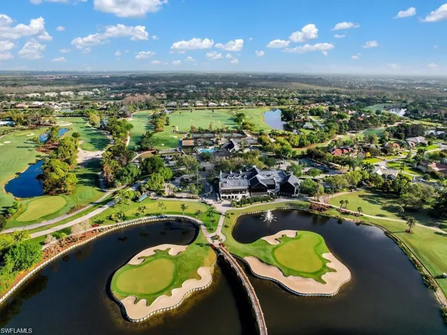 Aerial view of property's location featuring nearby suburban area, a large body of water, and a golf course