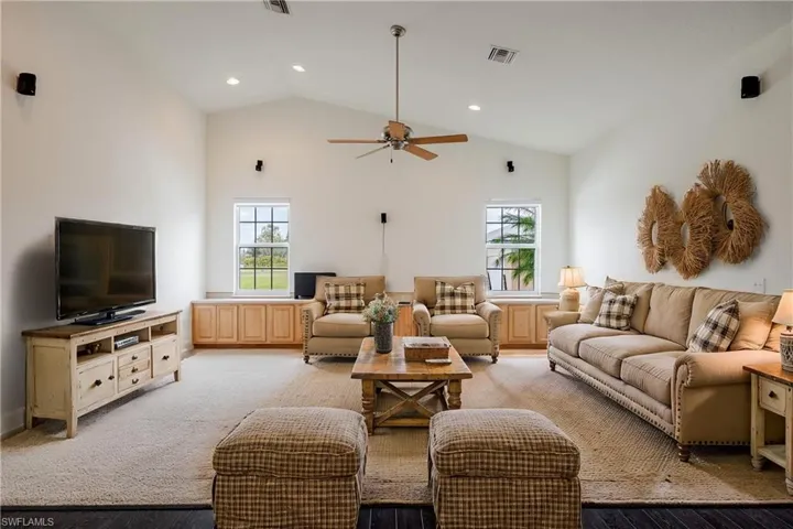 Living room featuring ceiling fan, plenty of natural light, high vaulted ceiling, and light hardwood / wood-style flooring