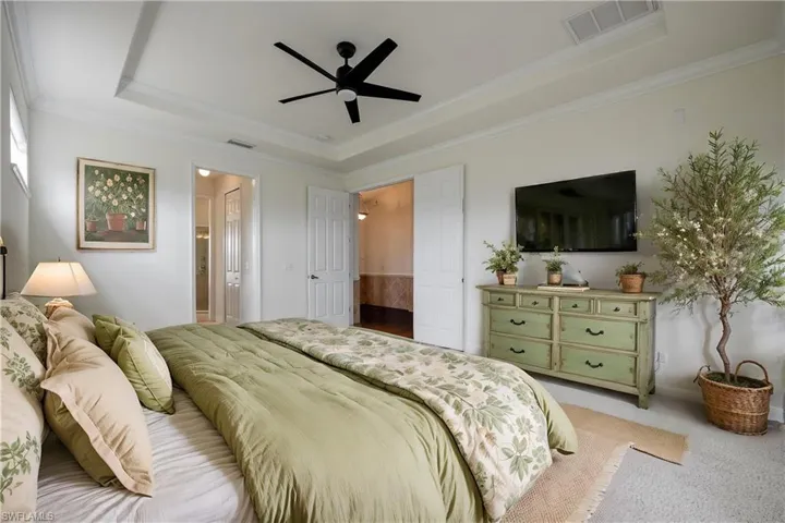 Primary bedroom with french doors leading to the pool/spa area.