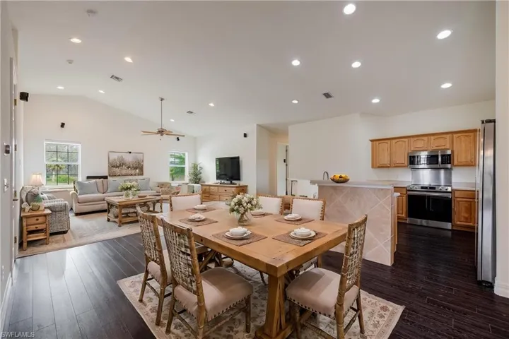 Dining room featuring ceiling fan, dark wood-type flooring, and lofted ceiling