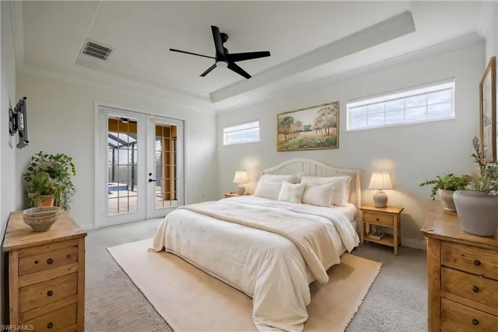 Primary bedroom with french doors leading to the pool/spa area.