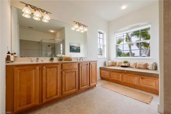 Primary bathroom featuring tile patterned flooring, vanity, and walk in shower