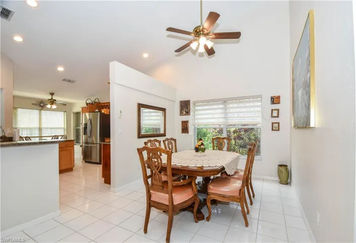 Dining space featuring ceiling fan, lofted ceiling, and light tile patterned floors