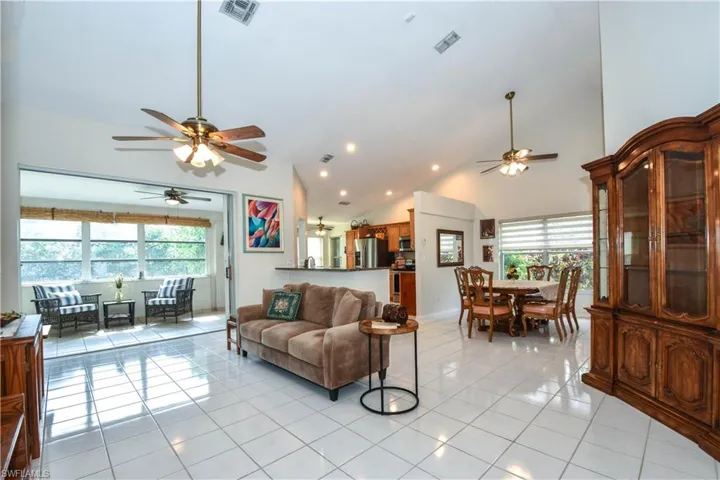 Living room with light tile patterned floors and high vaulted ceiling