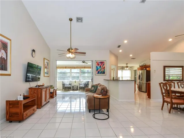 Living room with light tile patterned flooring and ceiling fan