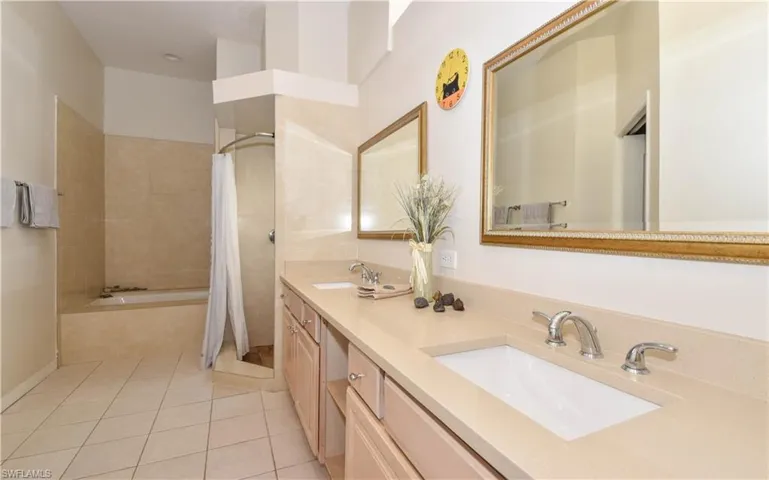 Updated Bathroom with Quartz Counters, Double Sinks, Separate Tub & Shower patterned flooring, vanity, and plus walk in shower