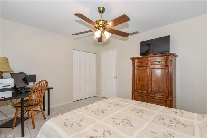 Tiled bedroom featuring a closet and ceiling fan