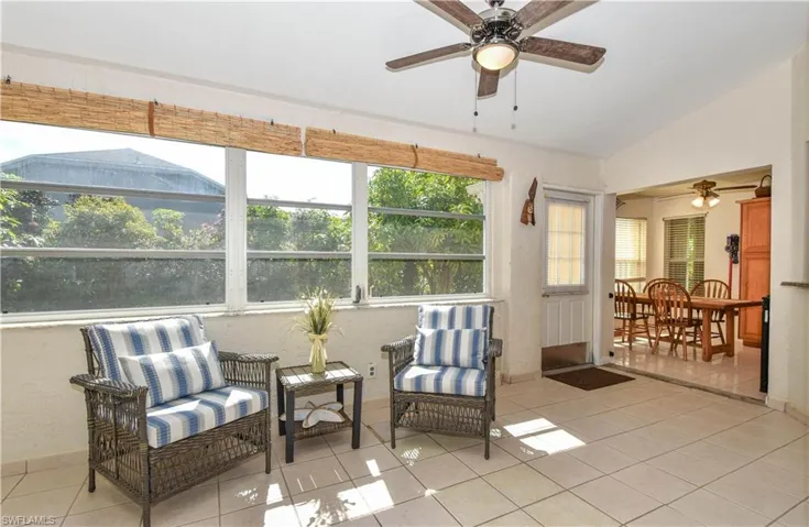 Florida Room with vaulted ceiling, light tile patterned floors, and ceiling fans