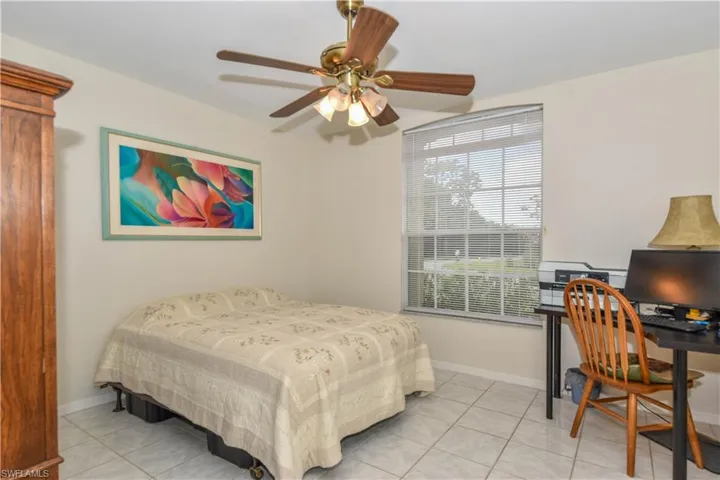 Bedroom with ceiling fan and light tile patterned floors